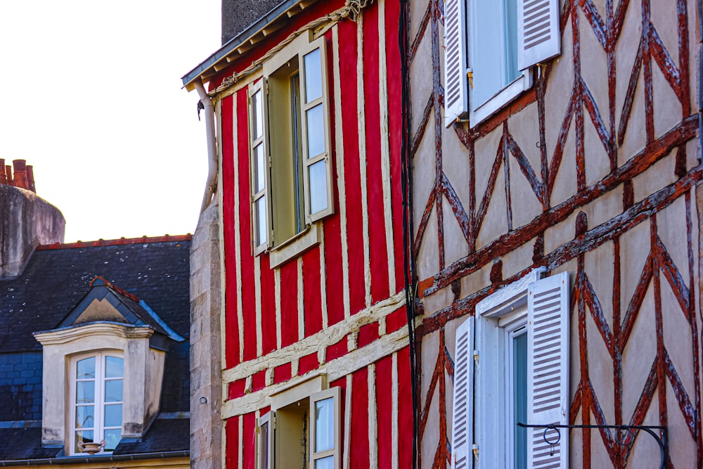 a red and white building with shutters and windows