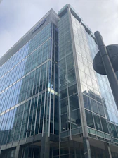 A sleek commercial building showcasing glass windows and steel framework in a cityscape.