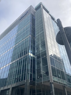 a tall glass building with a street light in front of it