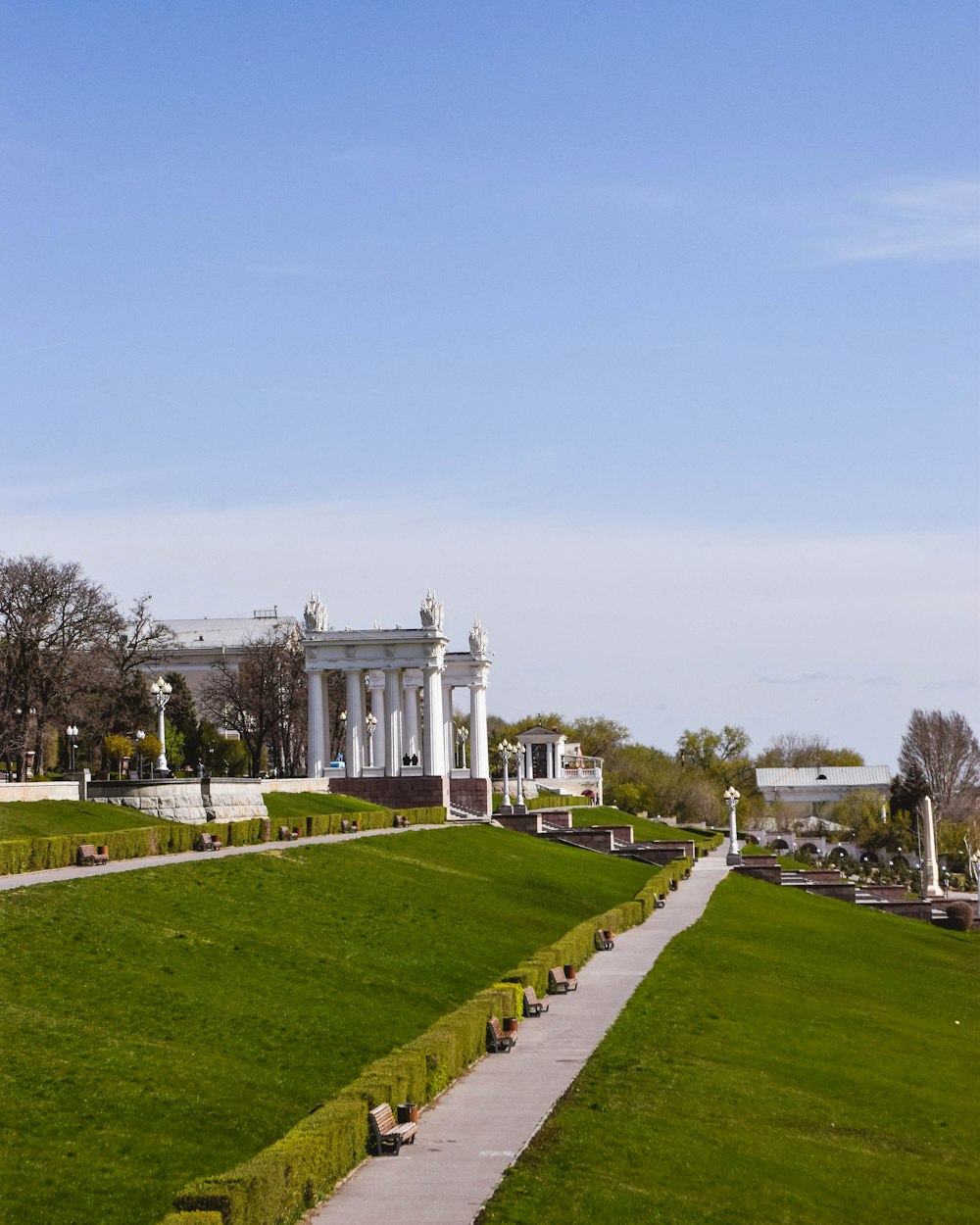 a large grassy field with a white building in the background