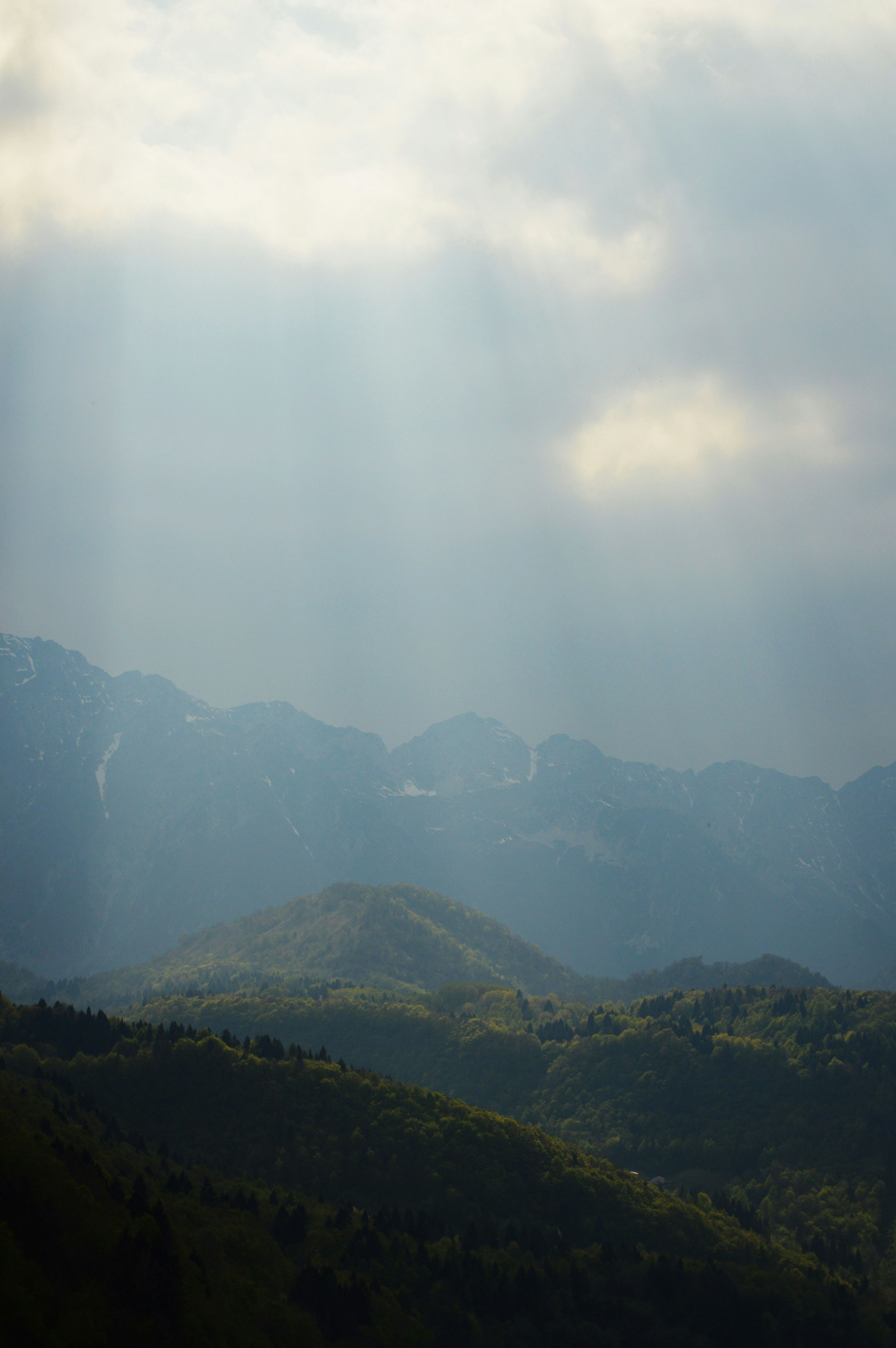 El sol brilla a través de las nubes sobre las montañas