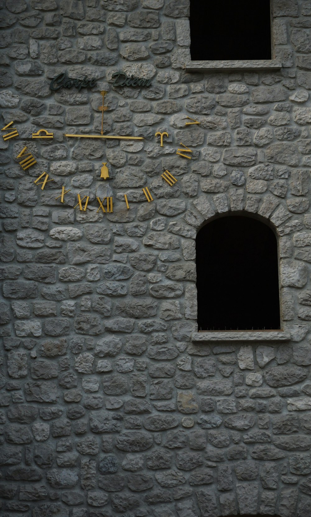 um relógio ao lado de um edifício de pedra