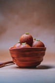 A warm, earthy-toned shot of coconut ladoos and imli ladoos resting on banana leaves.