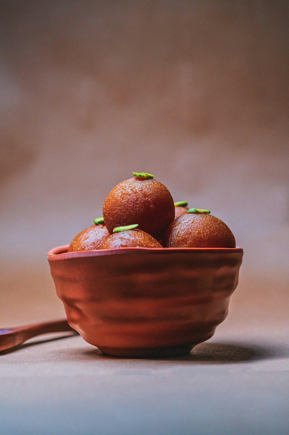 a red bowl filled with oranges on top of a table