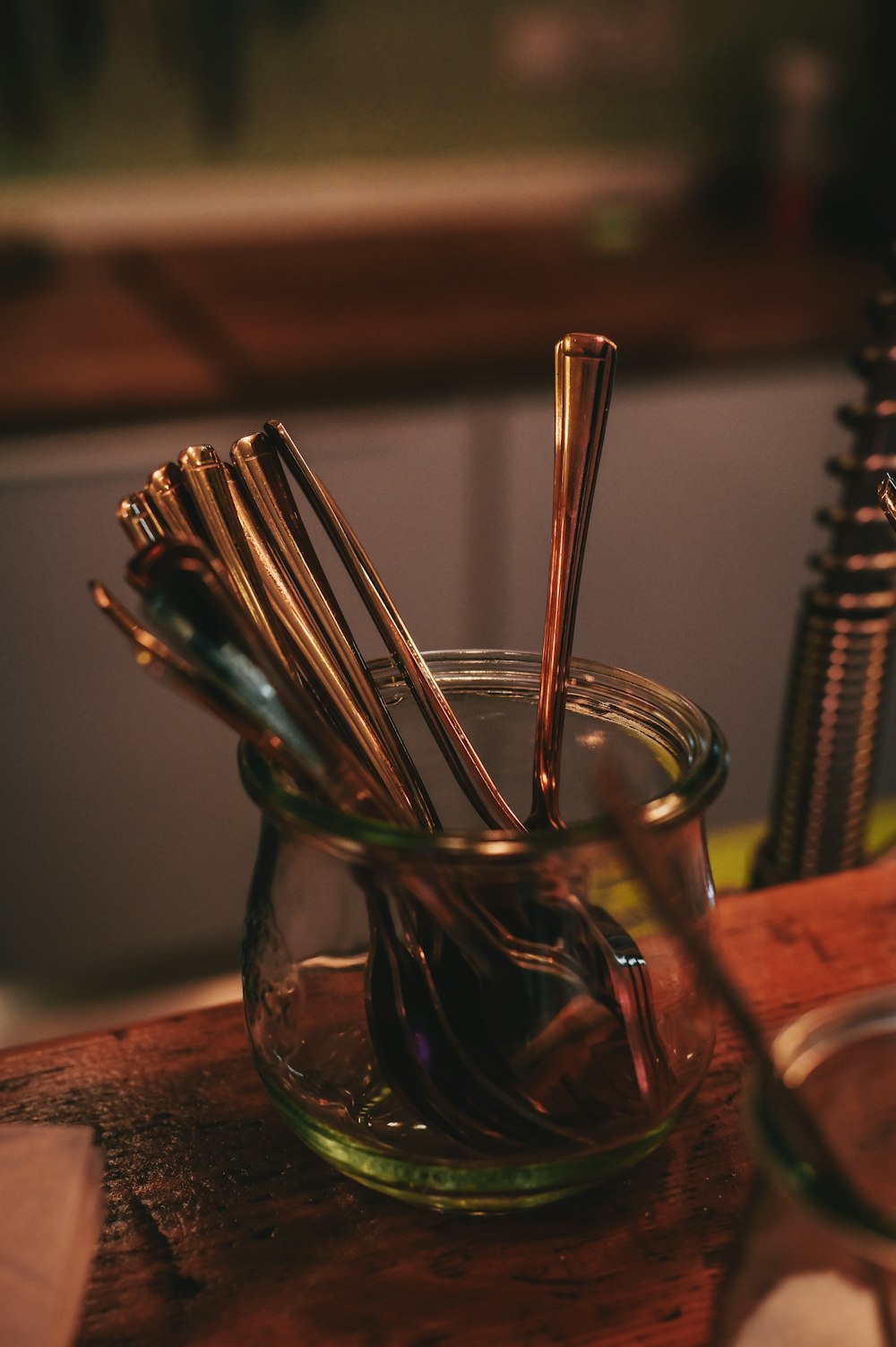 a glass filled with lots of metal utensils