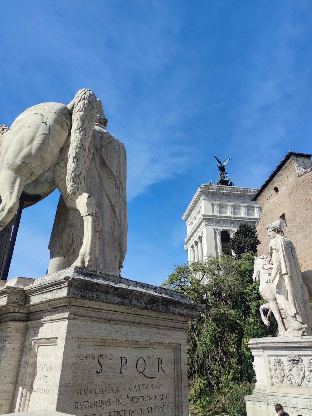 a statue of a man riding a horse in front of a building