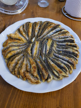 Freshly cleaned and cut fish pieces arranged neatly on a white plate ready for cooking