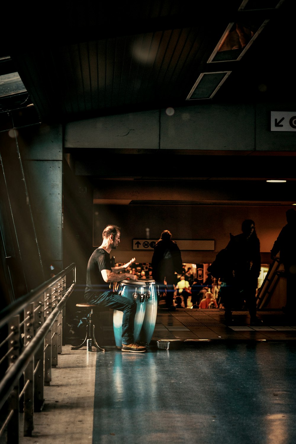 a man sitting on a chair playing a drum