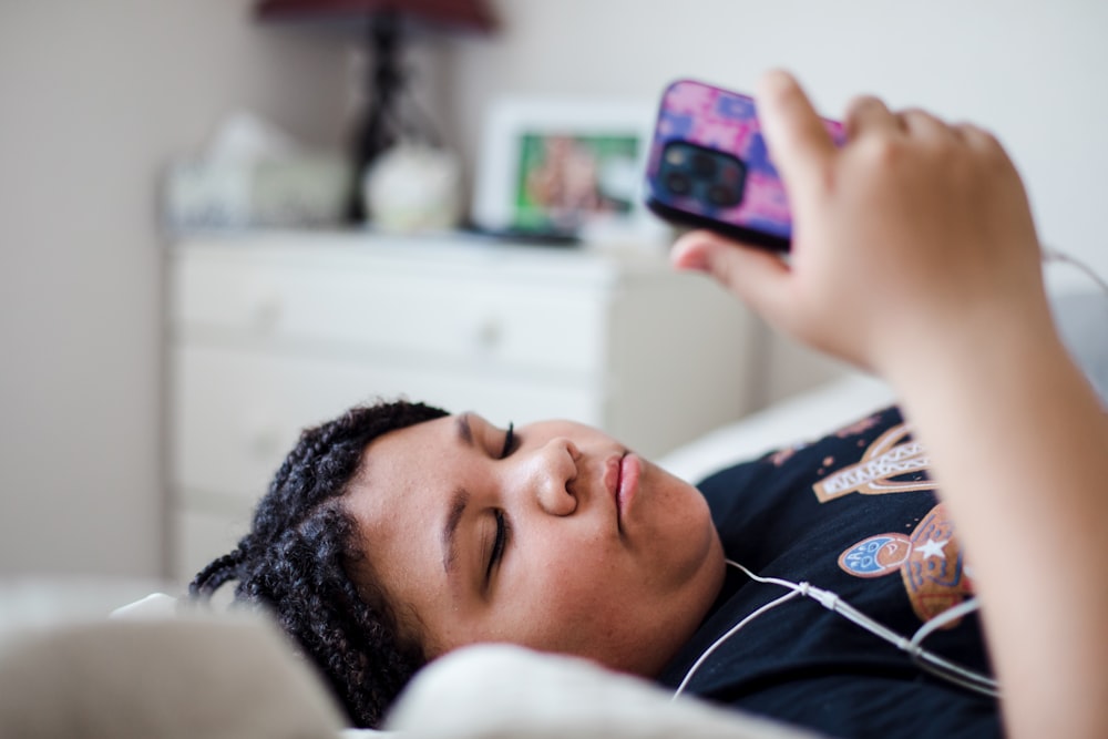 a person laying in bed with a cell phone