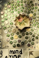 Close-up of hands crafting educational objects from recycled bottle caps.