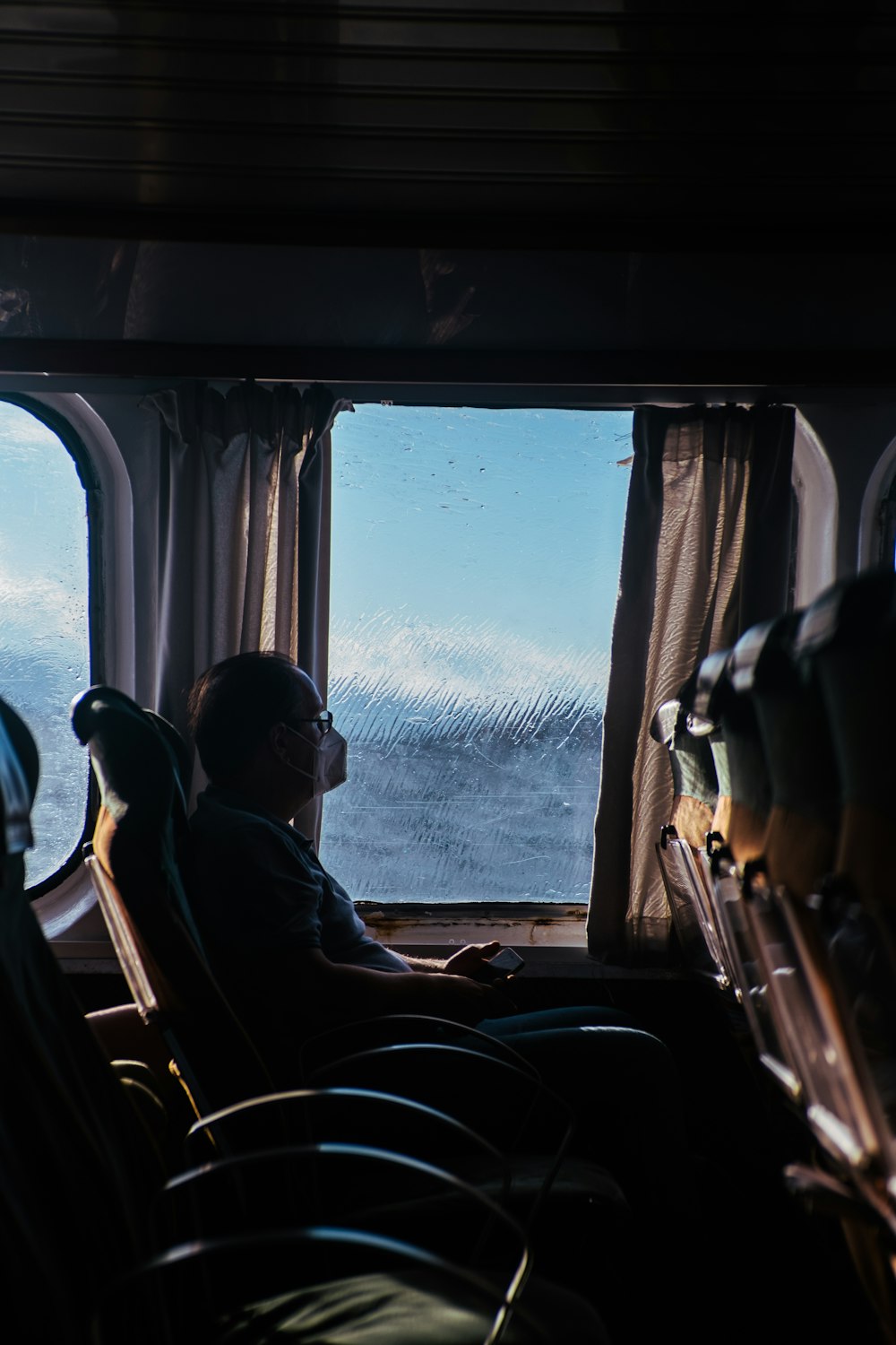 a man sitting on a train looking out the window