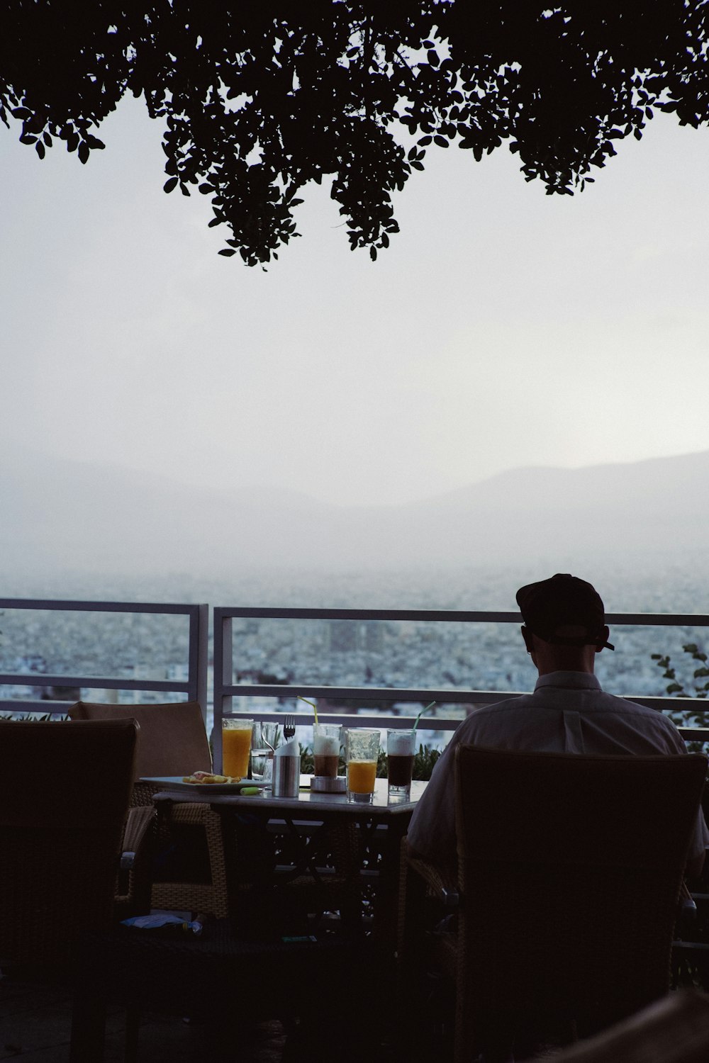a man sitting at a table with a view of the mountains