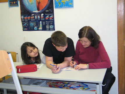 A happy child learning at home with a parent, surrounded by books and educational materials.