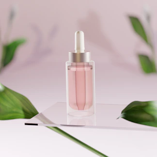 Close-up of a glass bottle of luminous liquid blush with a soft pink hue reflecting light.