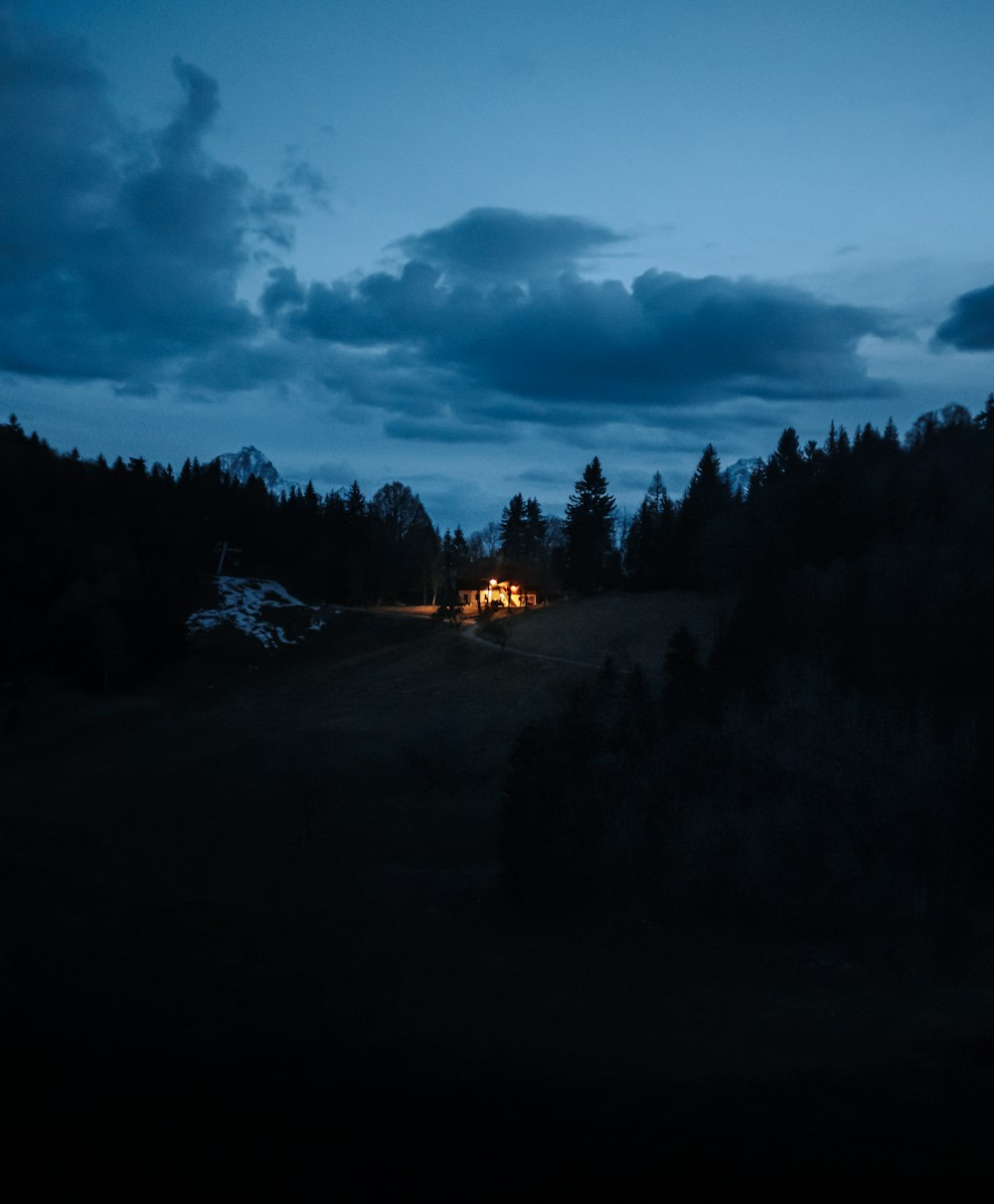 Une cabane est éclairée la nuit dans les bois