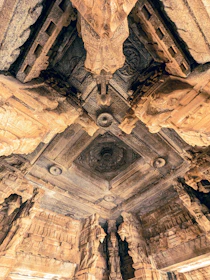 Intricate mandala patterns carved into ancient temple stone, bathed in warm light.
