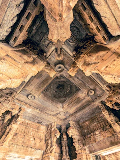 Intricate mandala patterns carved into ancient temple stone, bathed in warm light.