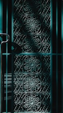 Close-up of wrought iron gate with intricate design in natural light.