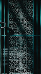 Close-up of a custom steel gate with intricate patterns in a residential setting.