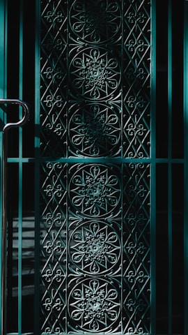 Close-up of a sturdy black metal gate with intricate geometric patterns.