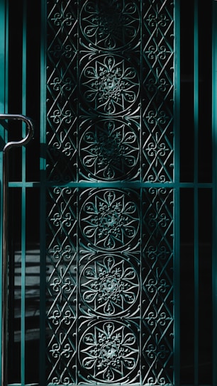 A close-up of a finely crafted metal gate with intricate geometric patterns.