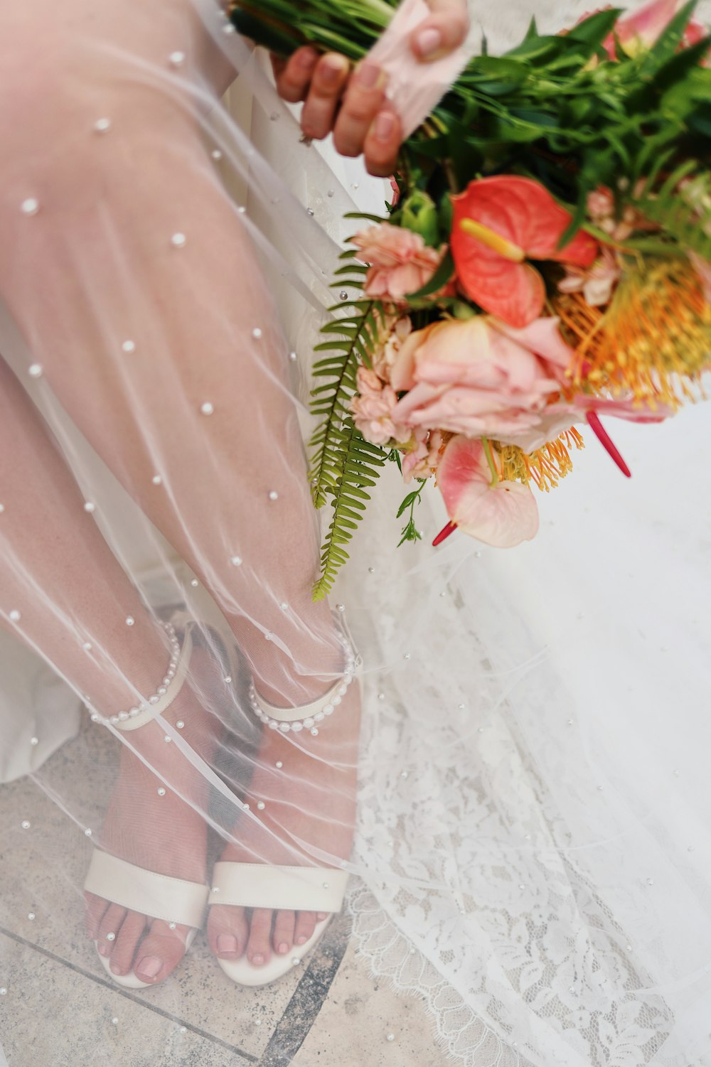 a woman in a wedding dress holding a bouquet of flowers