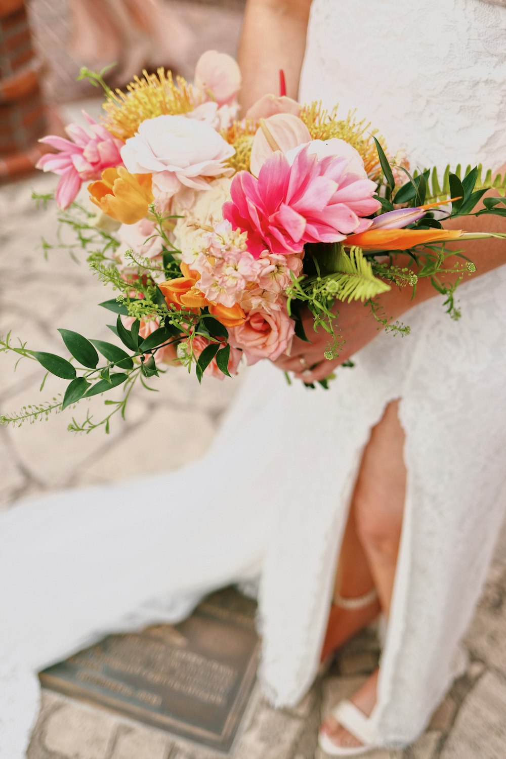 a woman in a white dress holding a bouquet of flowers