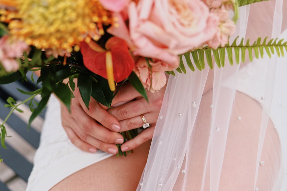 a close up of a person holding a bouquet of flowers