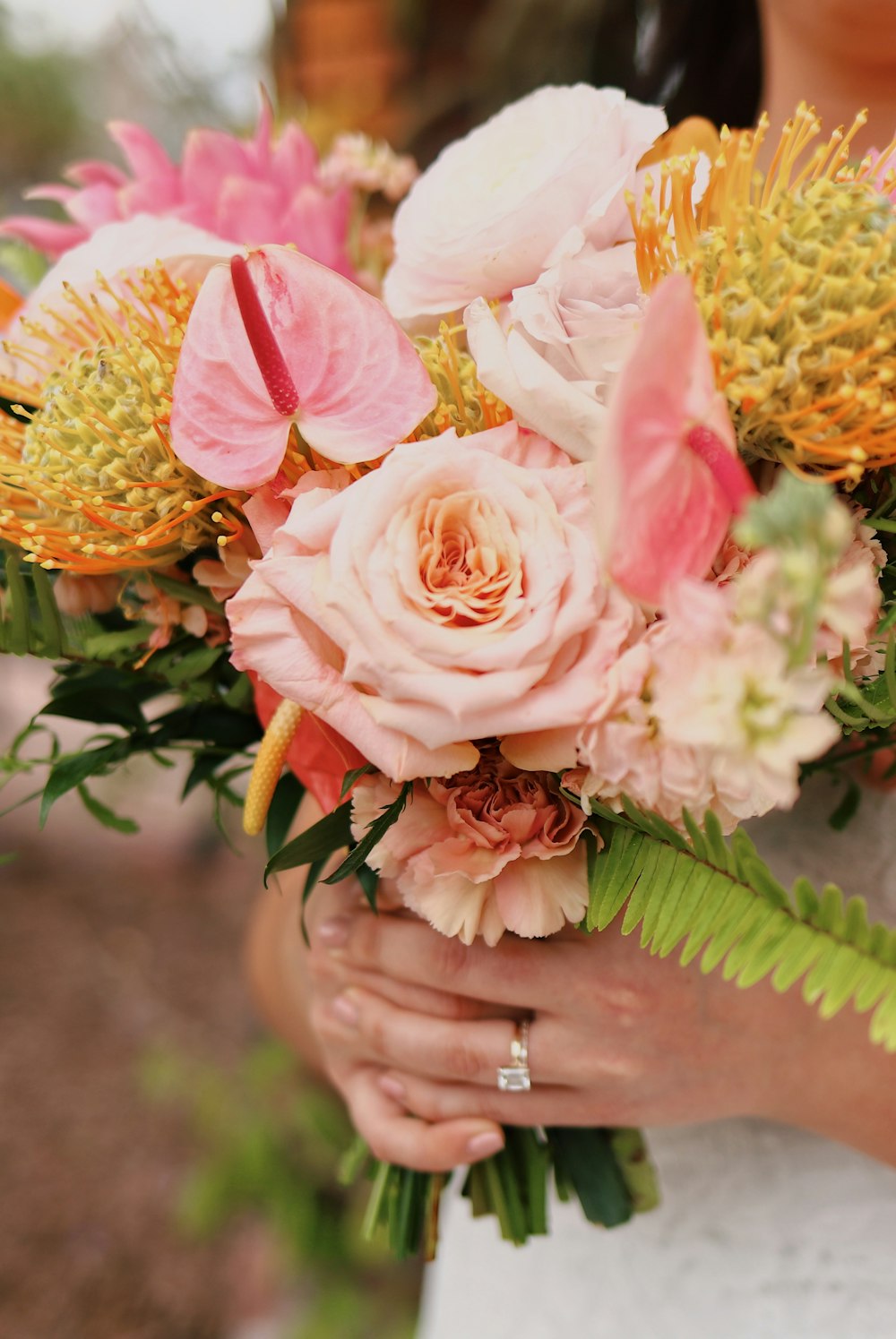a close up of a person holding a bouquet of flowers