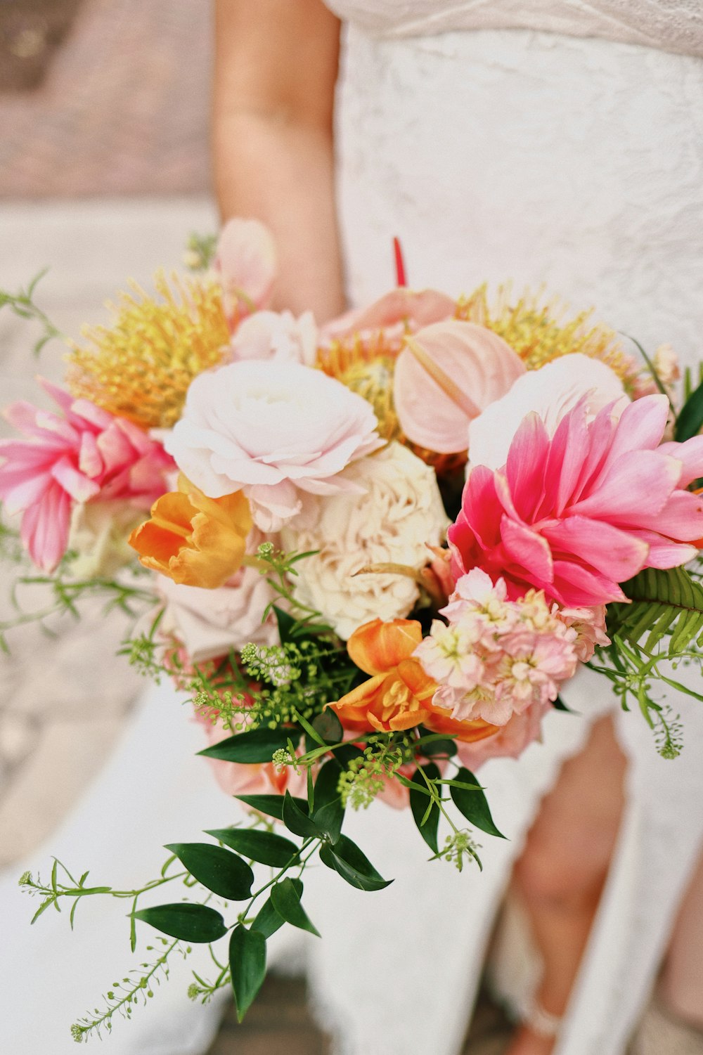 Une mariée tenant un bouquet de fleurs à la main