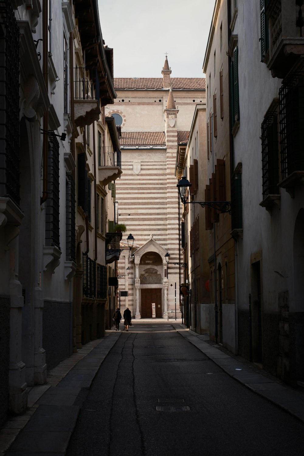 a narrow street with a tall building in the background