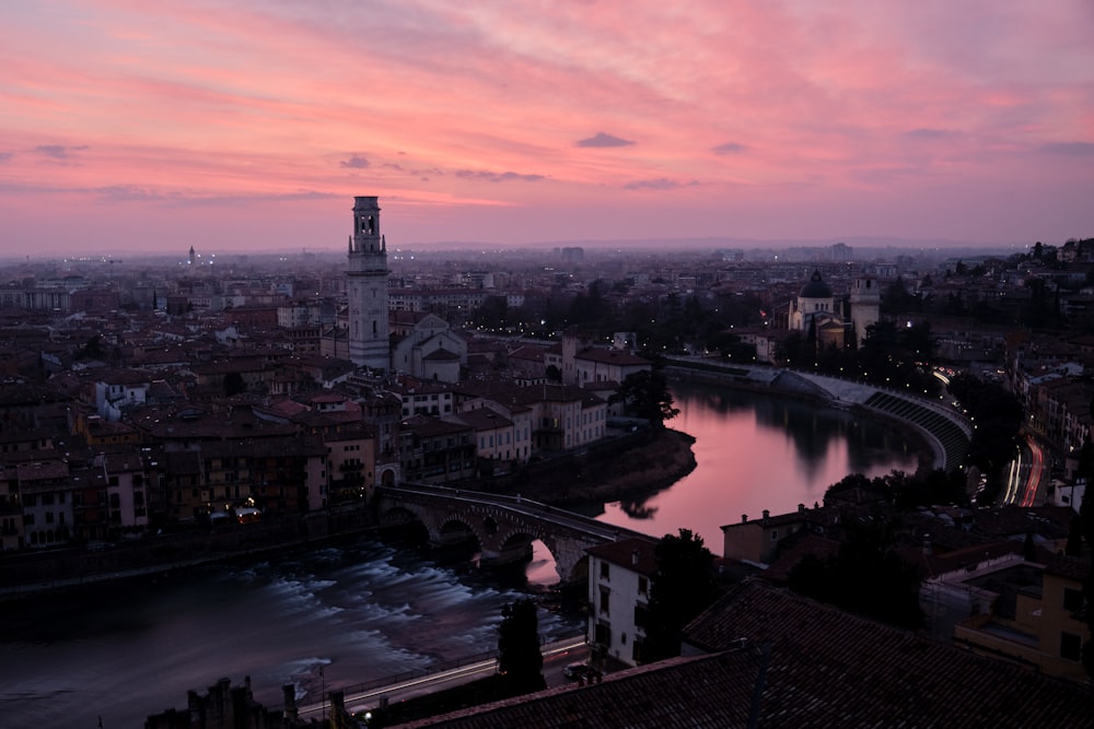 a sunset view of a city with a river running through it