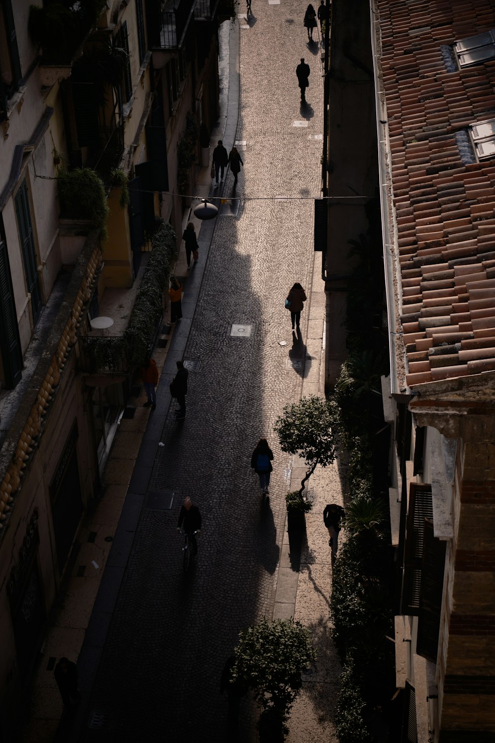 a group of people walking down a street next to tall buildings