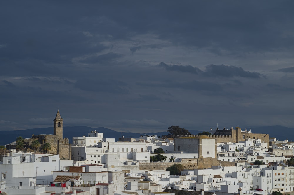 a city with white buildings under a cloudy sky
