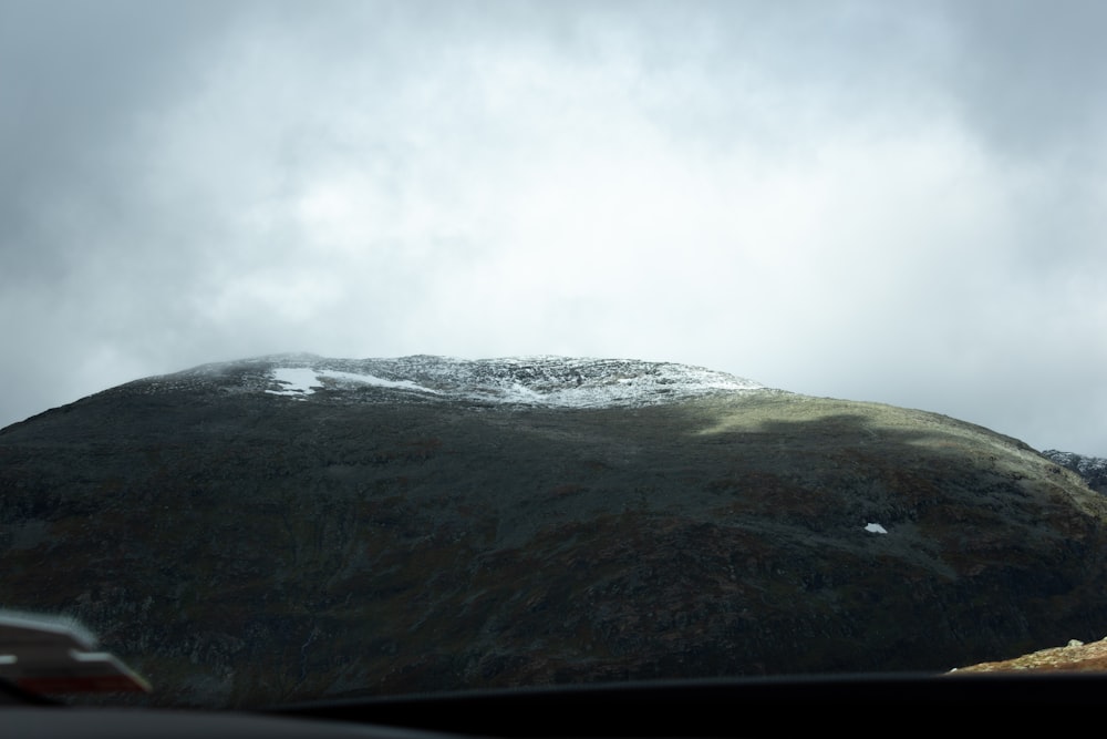 a car driving past a snow covered mountain