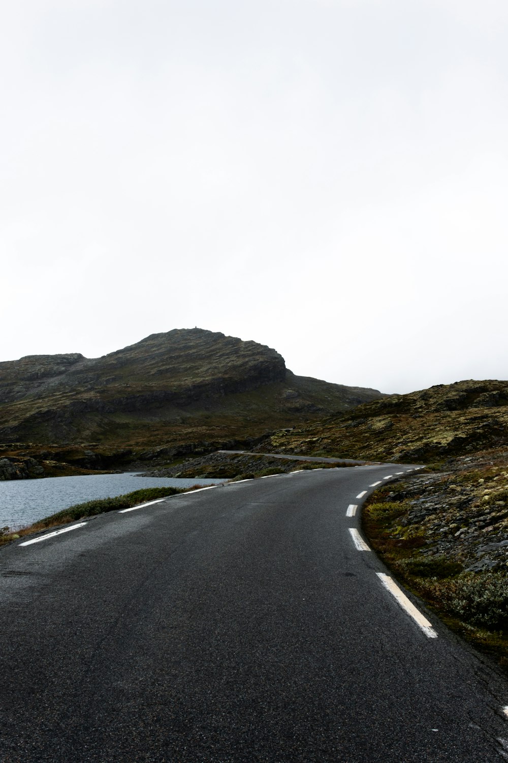 an empty road with a mountain in the background