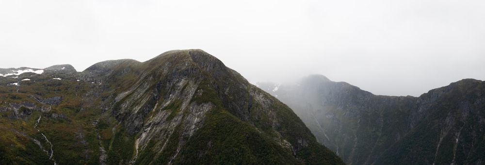 a very tall mountain in the middle of a foggy day