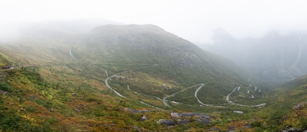 Eine kurvenreiche Bergstraße mitten in einem nebligen Tal