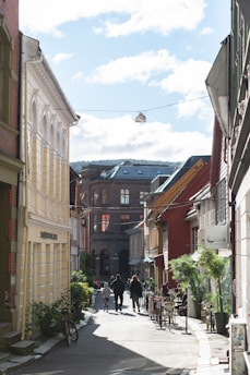 A sunny street in Seville with colorful buildings and a bike rental stand.