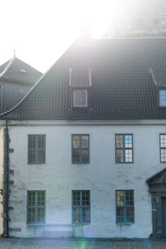Historic facade of the 100-year-old house before renovation, bathed in soft morning light.