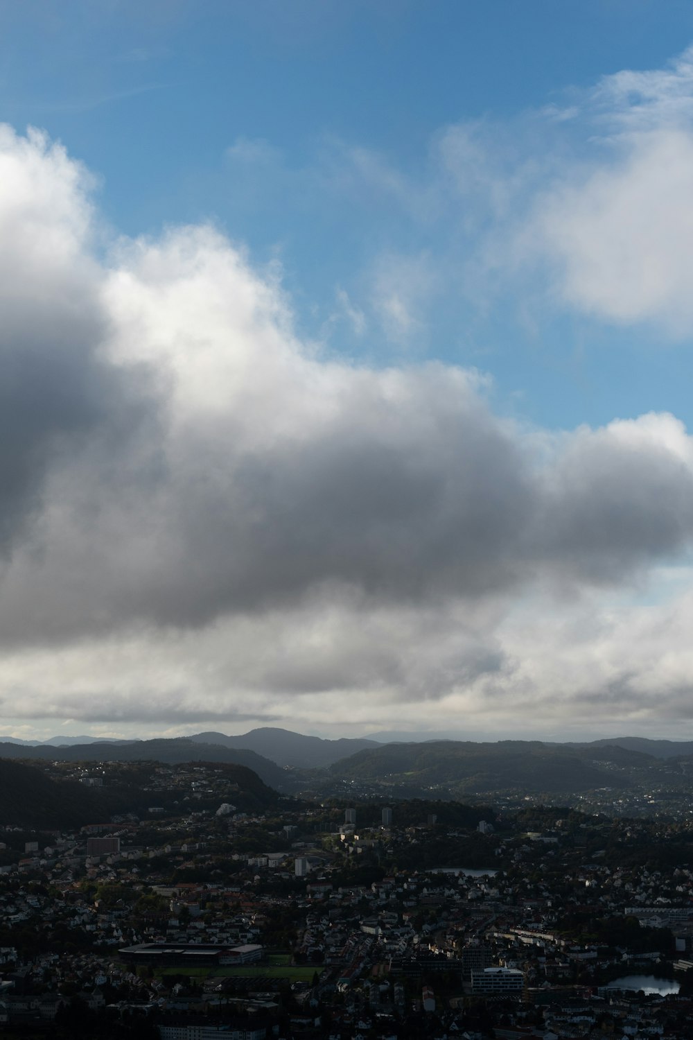 a city under a cloudy sky with a plane in the foreground