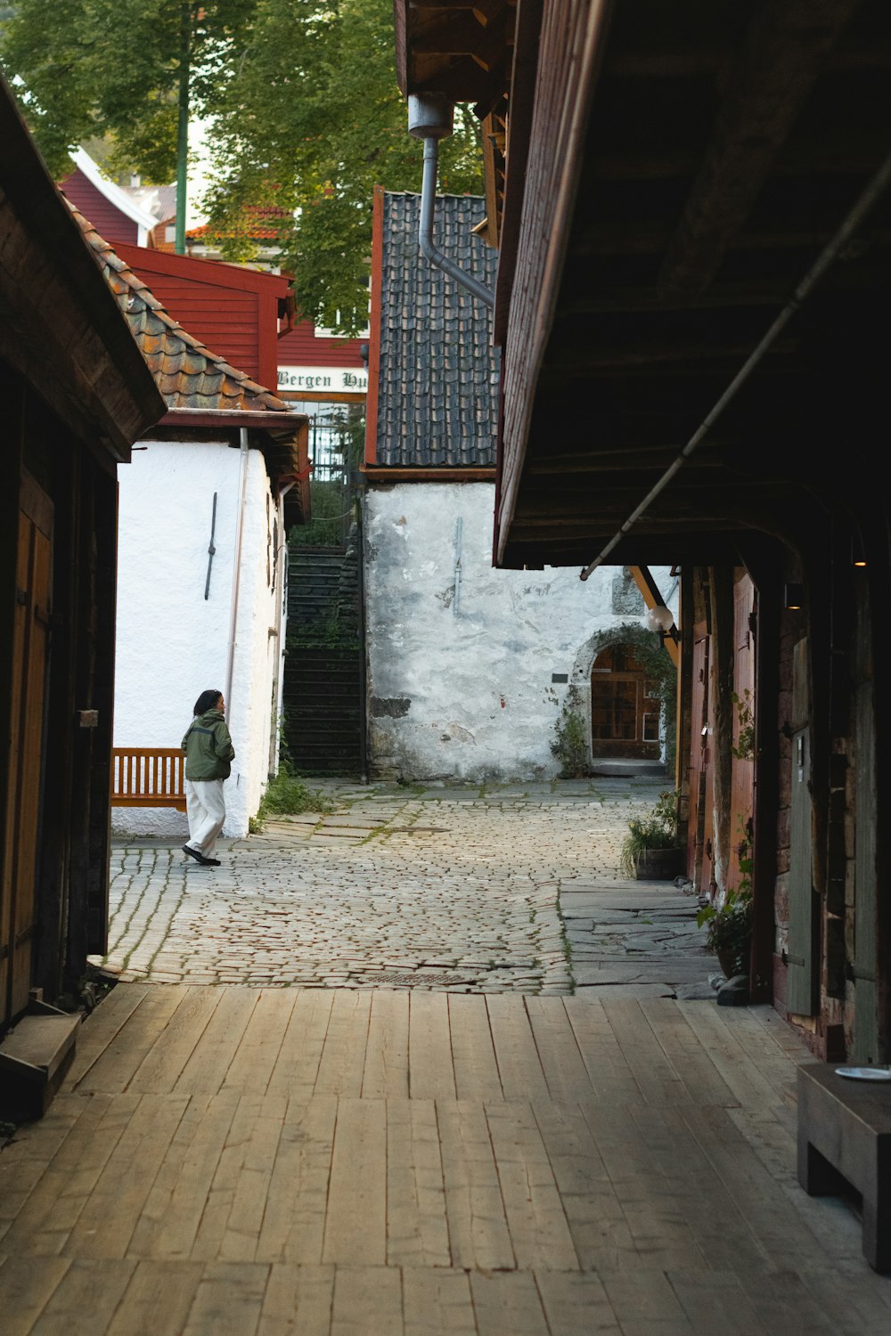 a person sitting on a bench in an alley