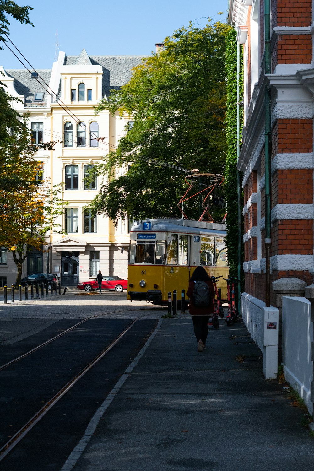 a yellow bus driving down a street next to tall buildings