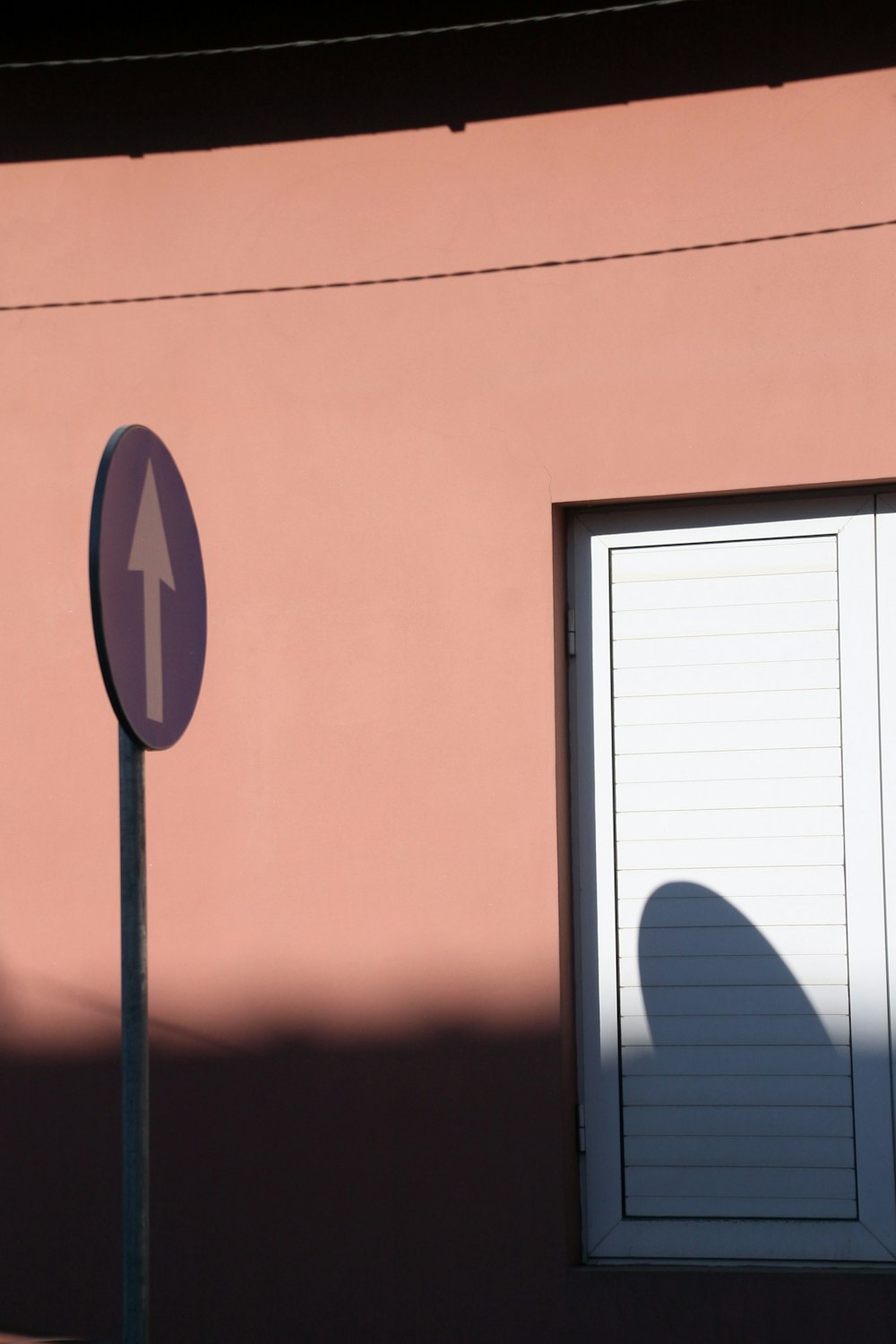 a street sign next to a pink building