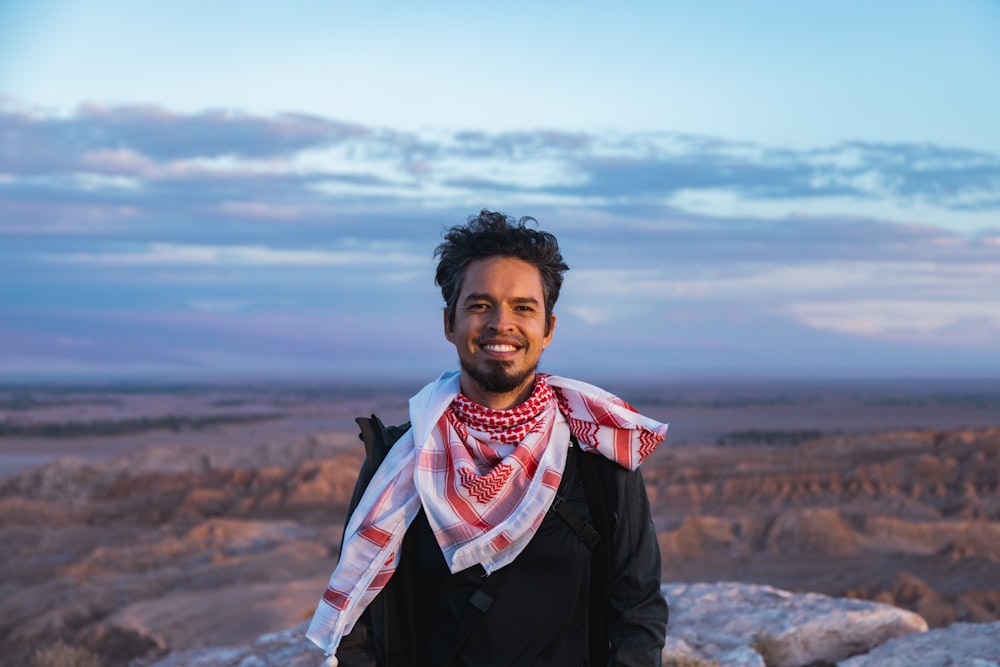 a man with a scarf around his neck posing for a picture