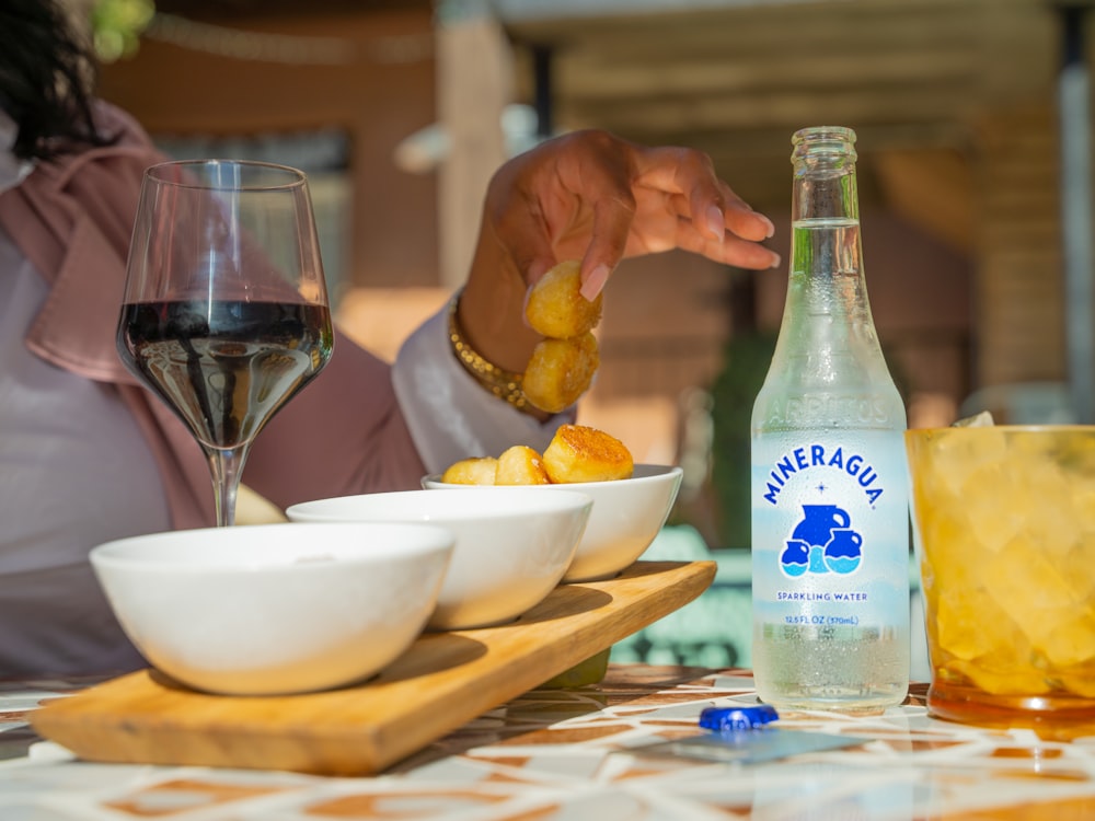 a person eating food with a glass of wine