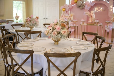 A beautifully decorated christening table with pastel balloons and delicate floral arrangements.