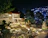 Close-up of a beautifully crafted stone patio with clean lines and elegant lighting at dusk.