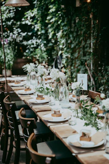a long table is set with plates and flowers