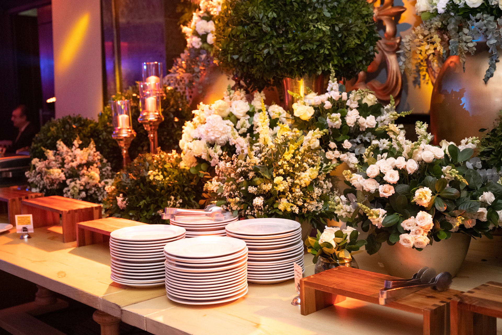 a table topped with plates and vases filled with flowers
